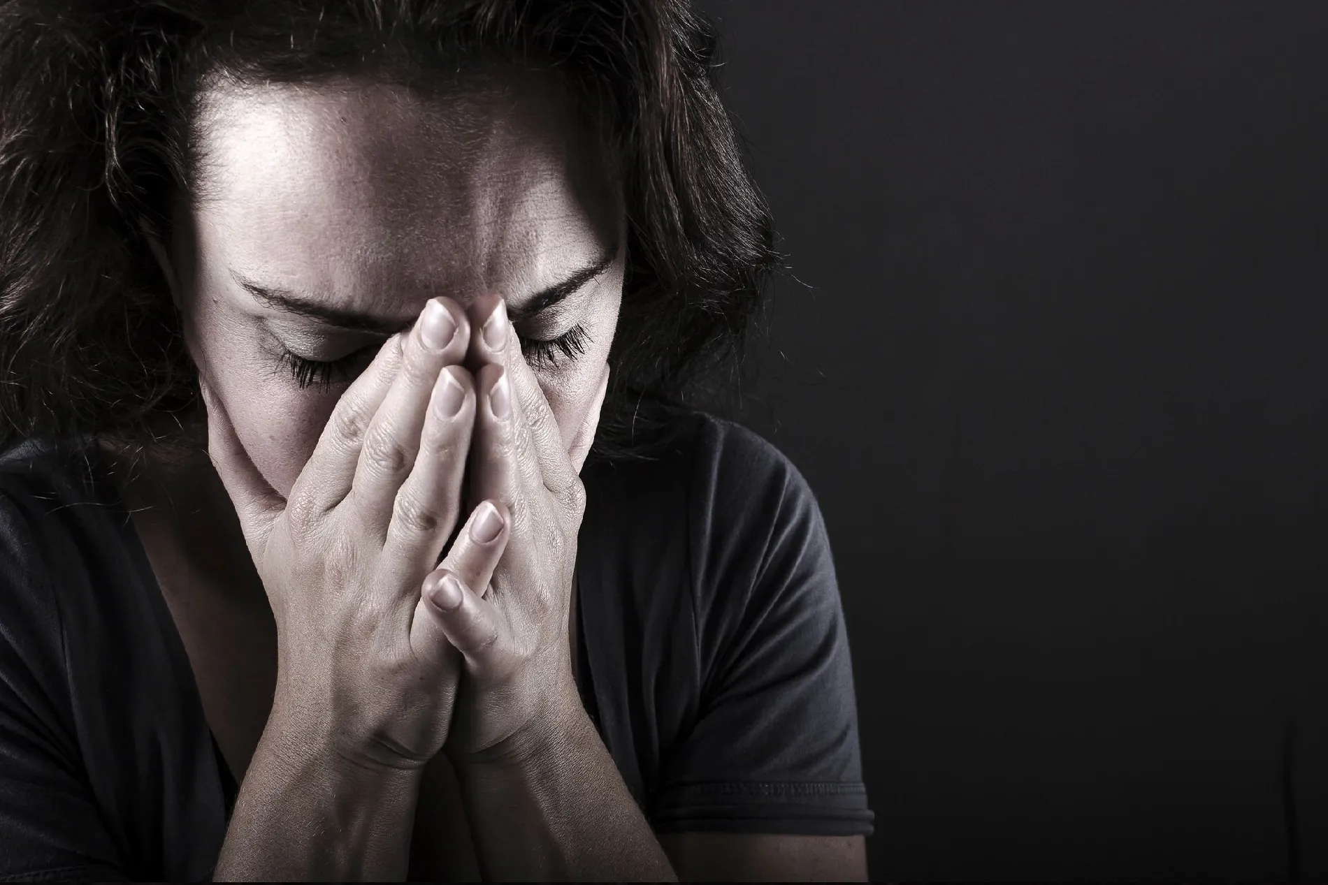 A person covering their face with their hands, conveying distress.