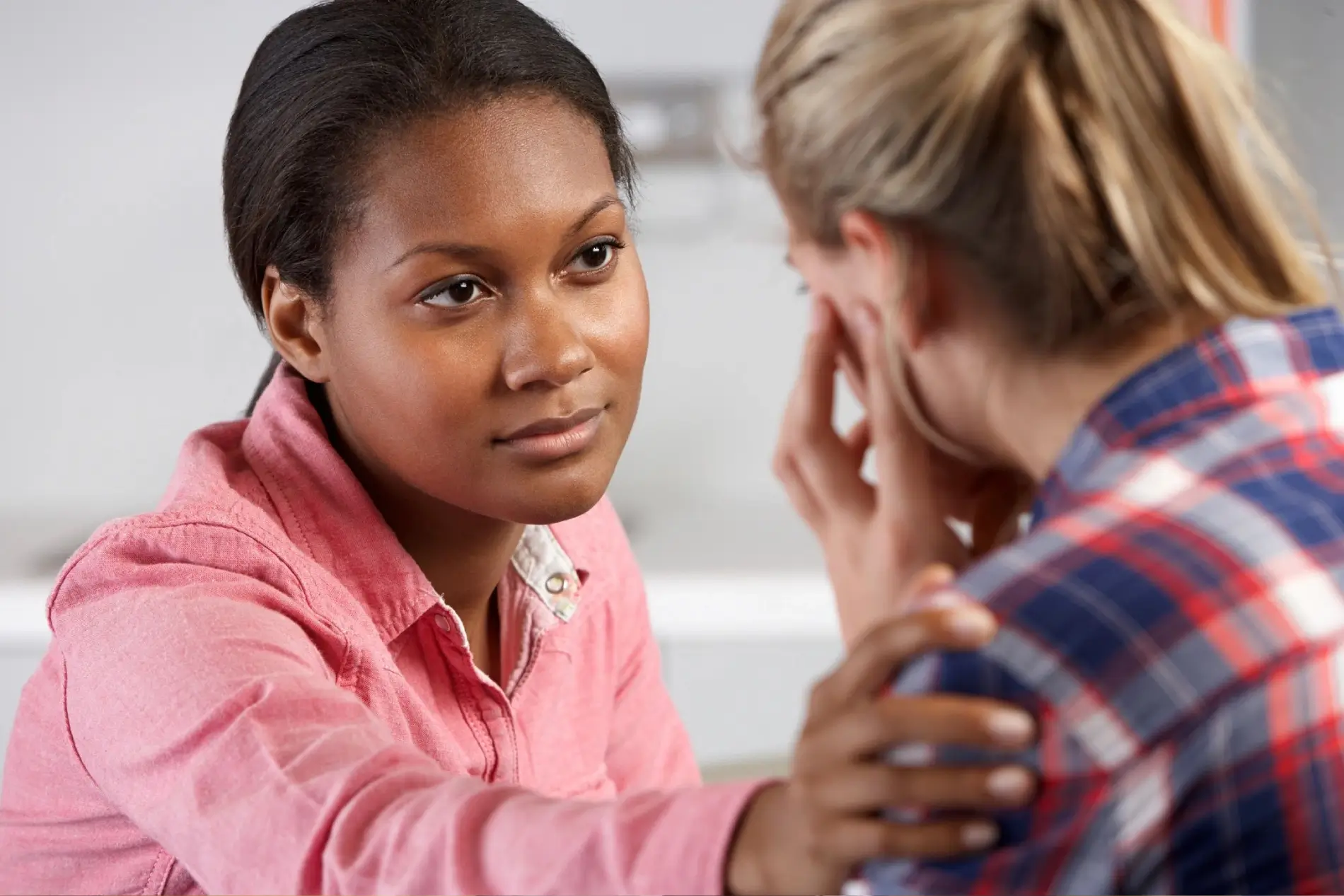 a woman consoling another woman